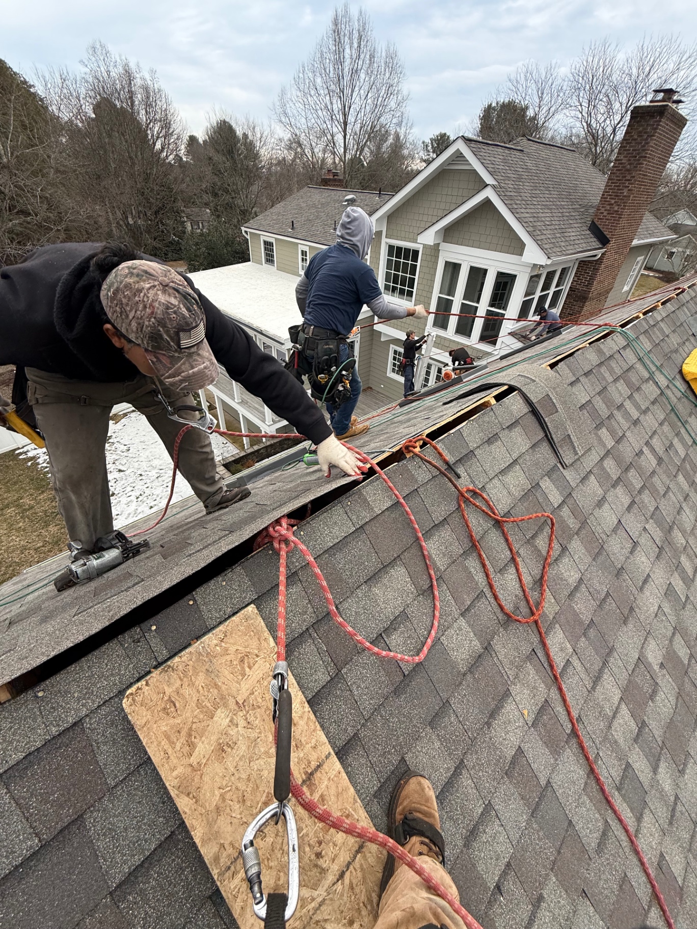 Magic RoofWorks crew installing shingles while tied off