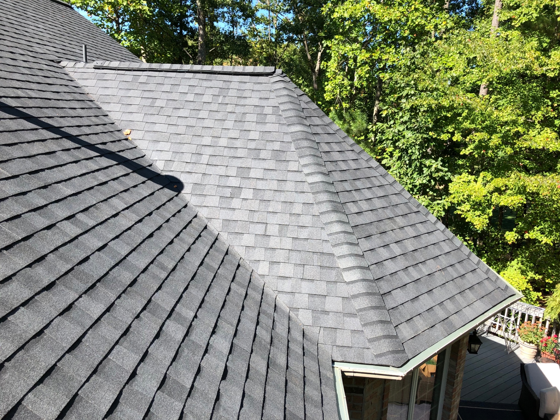 Close-up of dark grey architectural shingles with ridge vent detail