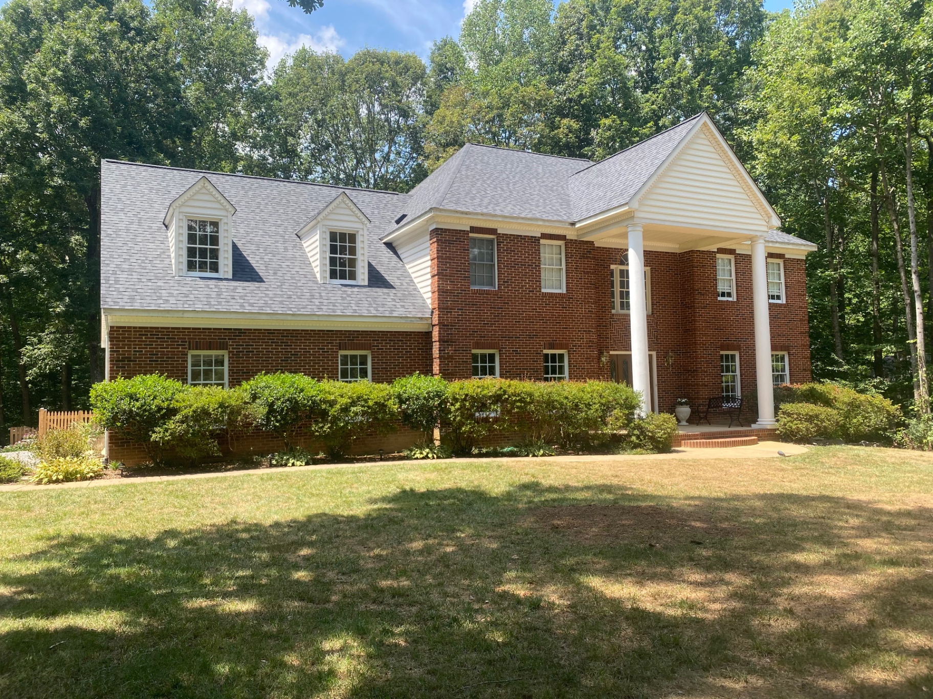 Brick colonial with a new architectural shingle roof and dormers