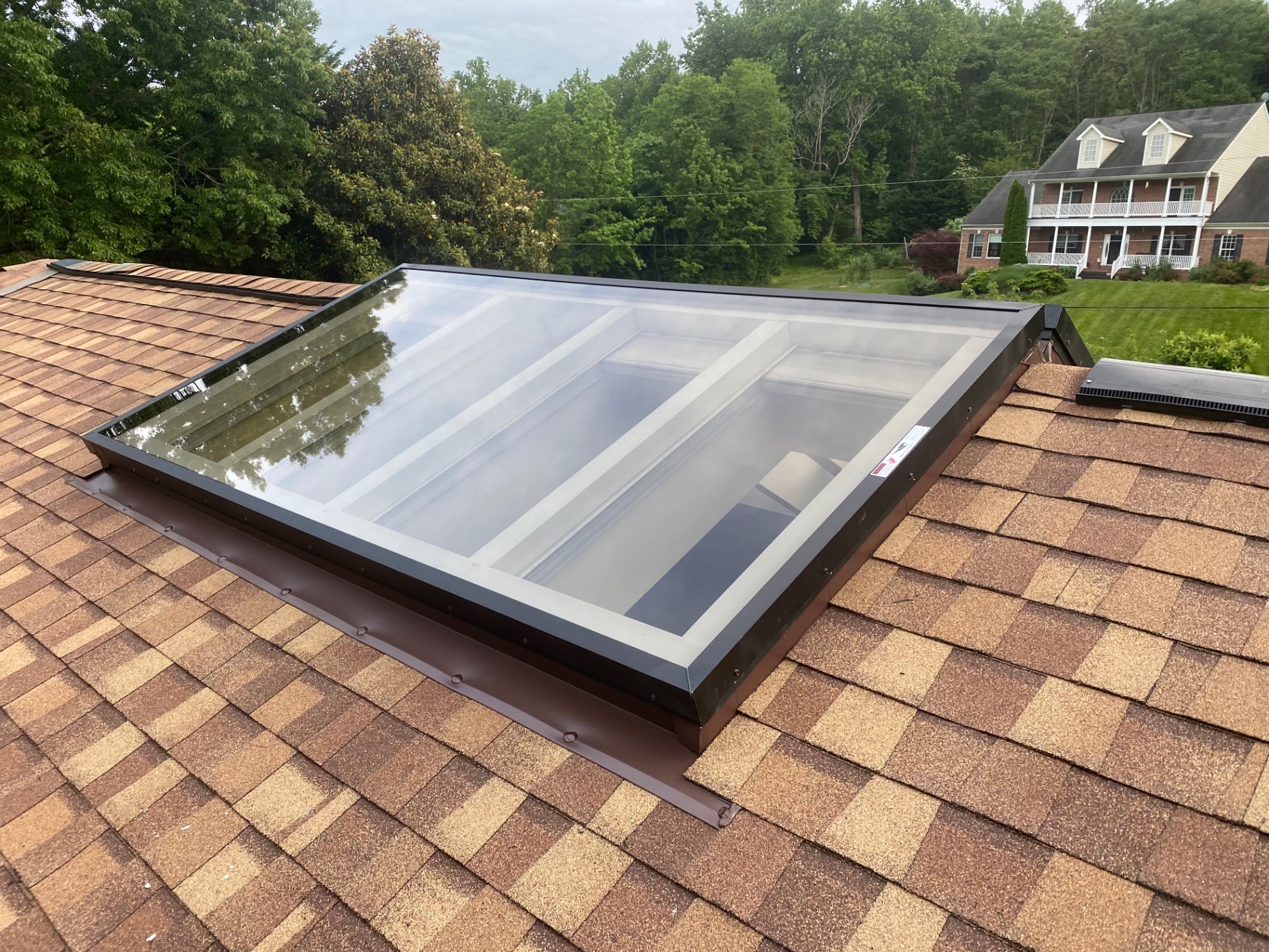 New skylight installation with custom flashing on a shingle roof
